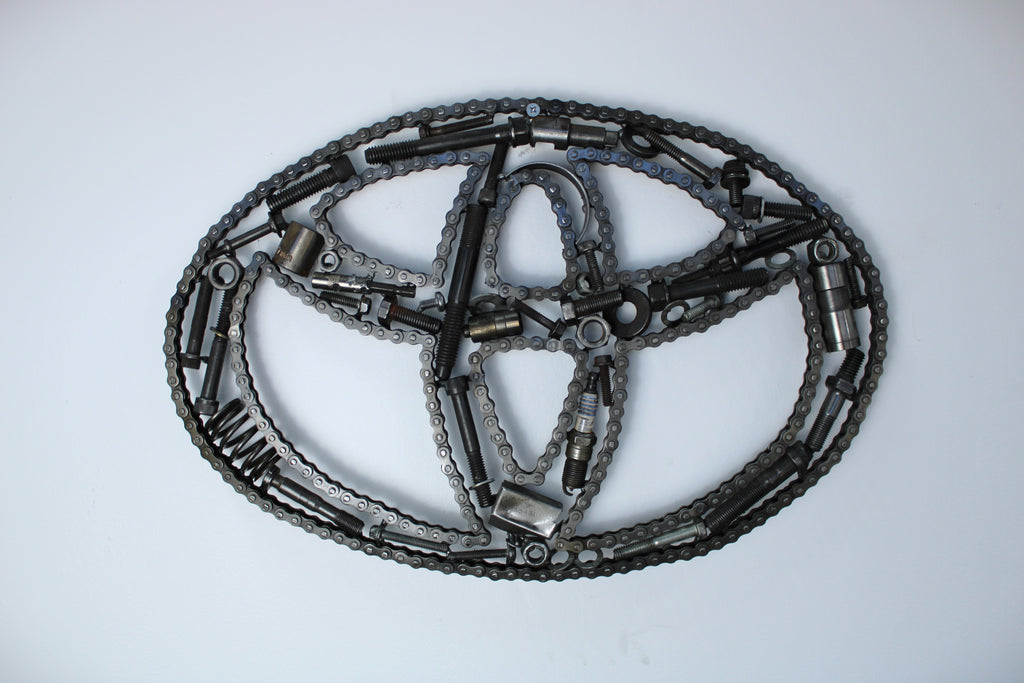 Toyota logo wall art made out of real car parts and outlined with timing chain.