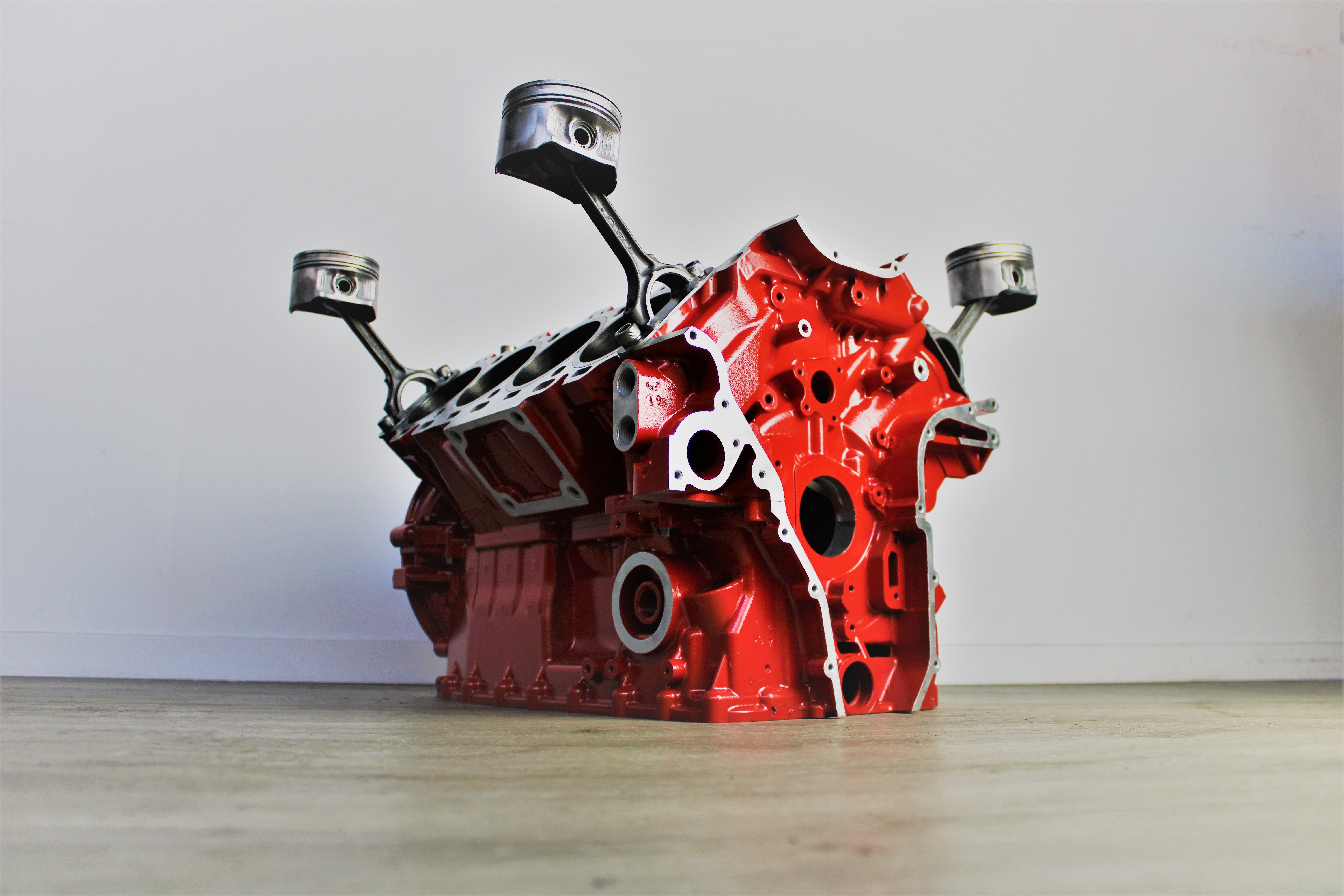 Ferrari engine block coffee table finished in red without its glass top.