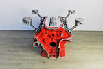 Load image into Gallery viewer, Ferrari engine block coffee table finished in red without its glass top, the Ferrari logo displayed in the center.
