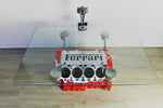 Load image into Gallery viewer, Ferrari engine block coffee table finished in red with a square glass top, the Ferrari logo displayed in the center and a car piston clock on top.

