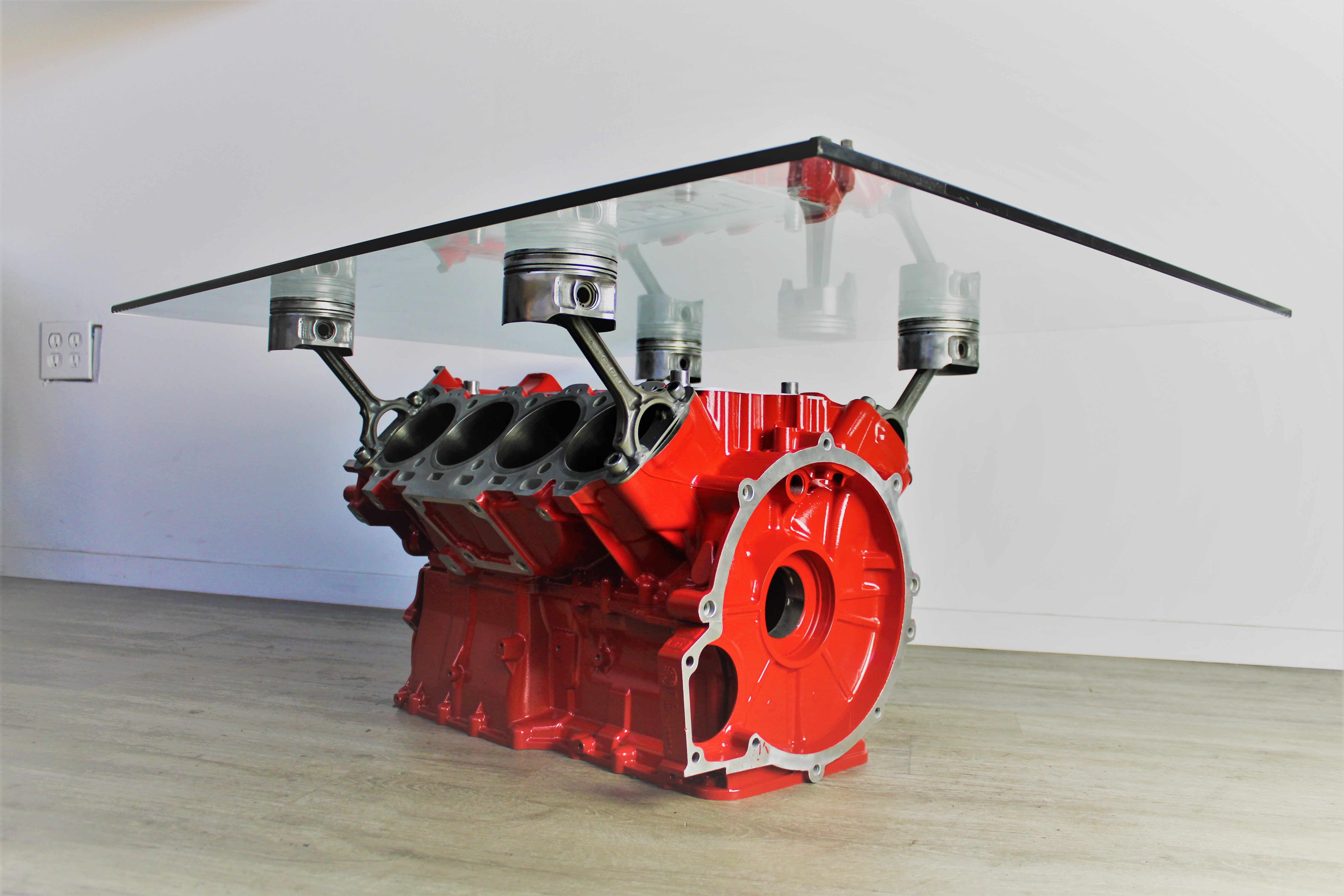Ferrari engine block coffee table finished in red with a square glass top.