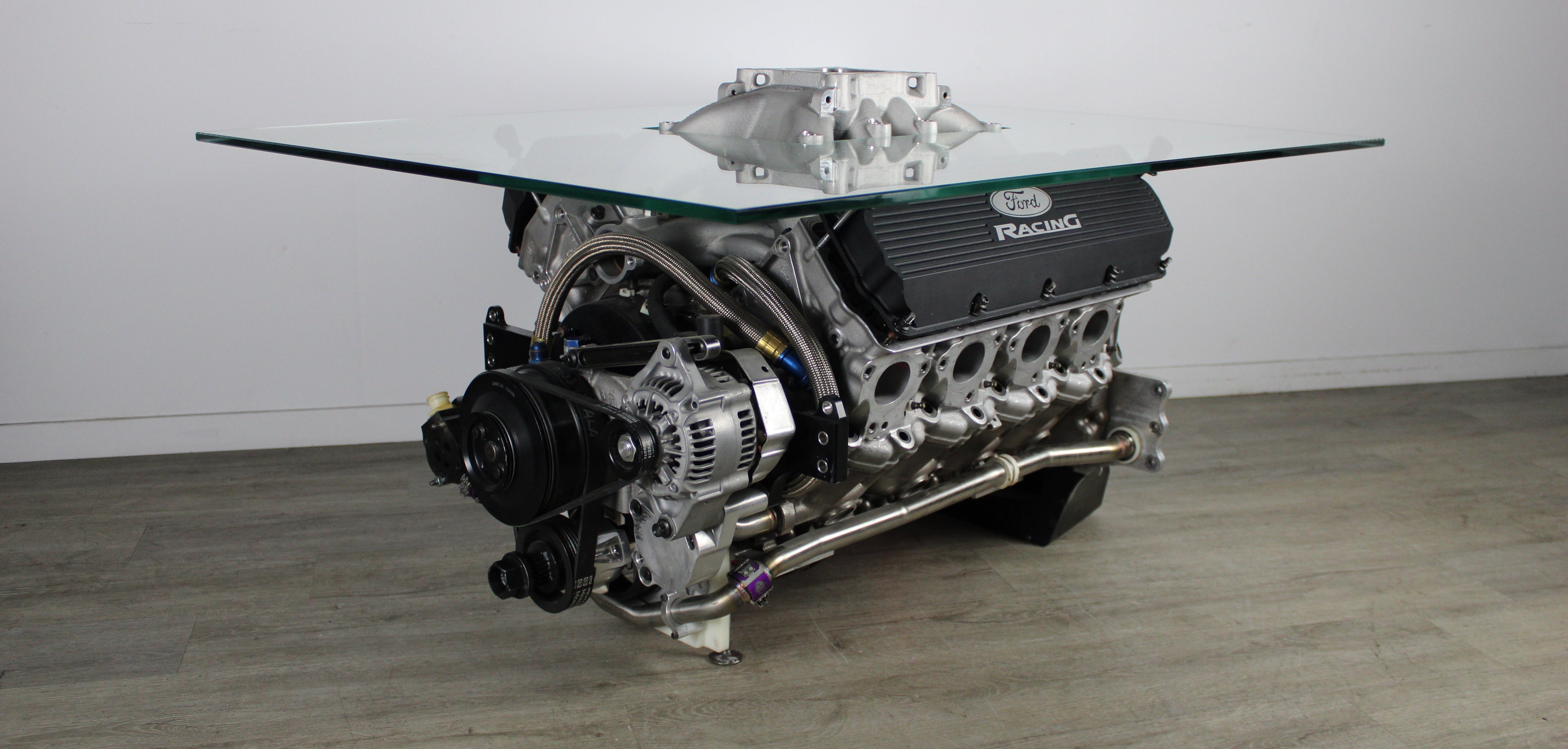 Engine-themed coffee table with glass top on a wooden floor