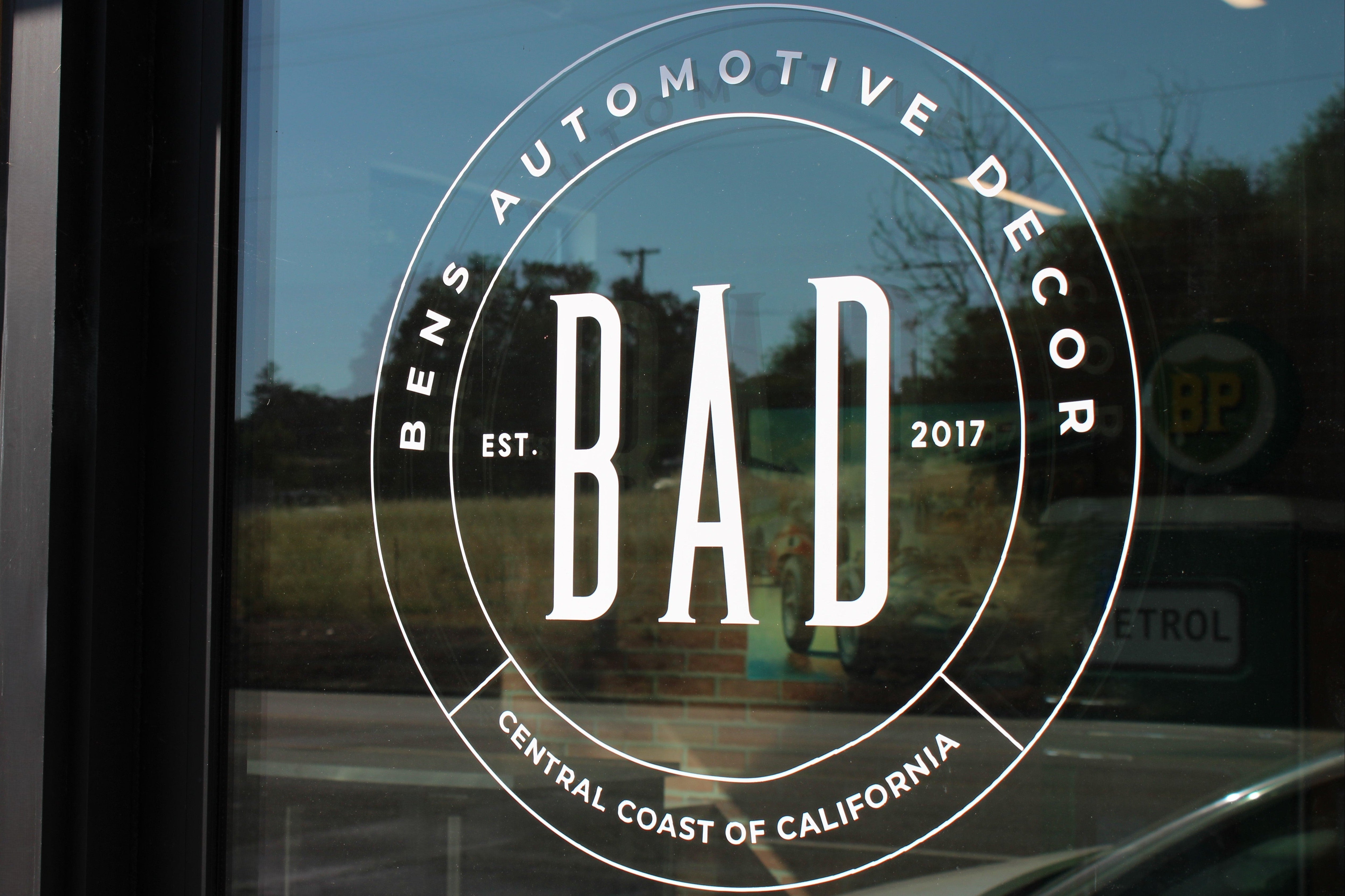 Window with 'BAD' logo and 'Bens Automotive Decor' text on a glass door.