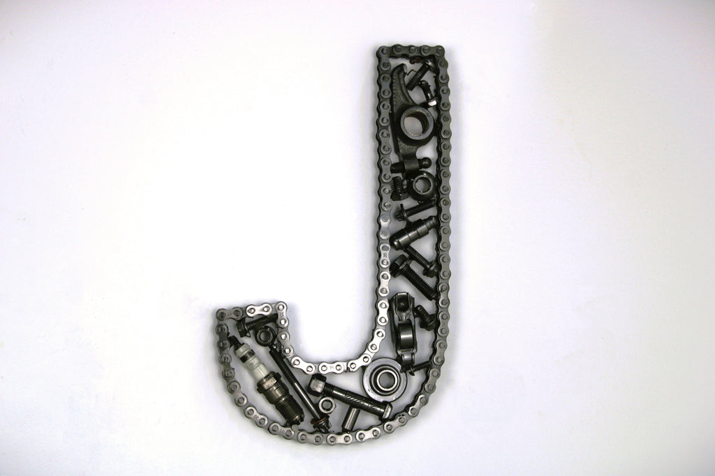 A letter J made out of real car parts, outlined with a timing chain.