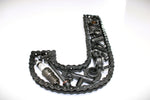 Load image into Gallery viewer, Close-up view of a letter J made out of real car parts, outlined with a timing chain.
