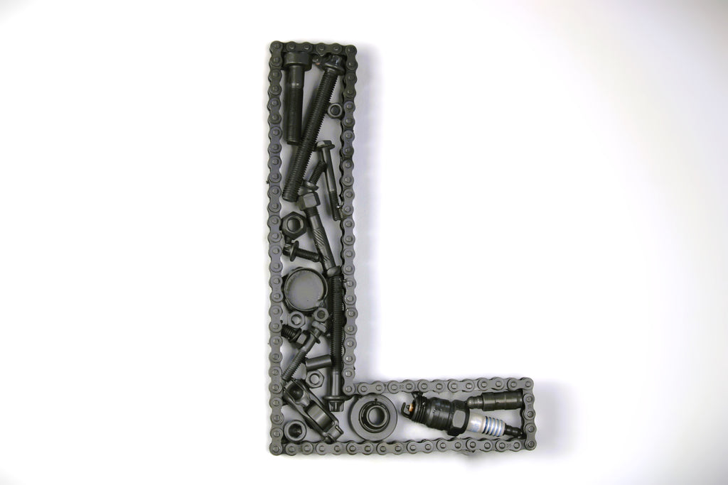 A letter L made out of real car parts, outlined with a timing chain.