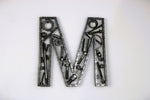 Load image into Gallery viewer, A letter M made out of real car parts, outlined with a timing chain.
