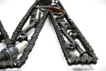 Load image into Gallery viewer, Close-up view of a letter M made out of real car parts, outlined with a timing chain.
