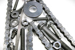 Load image into Gallery viewer, Close-up view of a letter N made out of real car parts, outlined with a timing chain.
