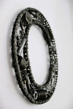 Load image into Gallery viewer, Close-up view of a letter O made out of real car parts, outlined with a timing chain.
