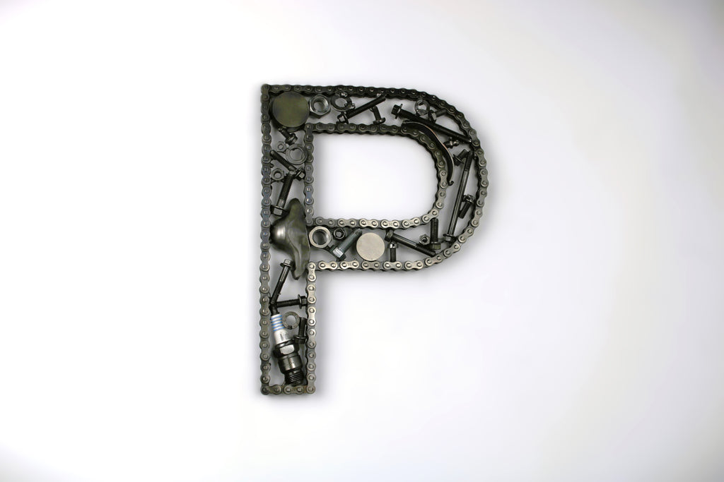A letter P made out of real car parts, outlined with a timing chain.