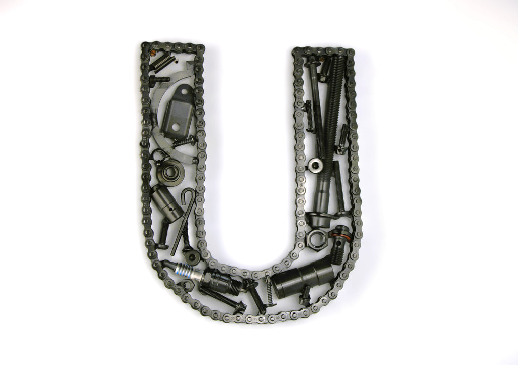 A letter U made out of real car parts, outlined with a timing chain.