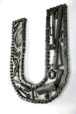 Load image into Gallery viewer, Close-up view of a letter U made out of real car parts, outlined with a timing chain.
