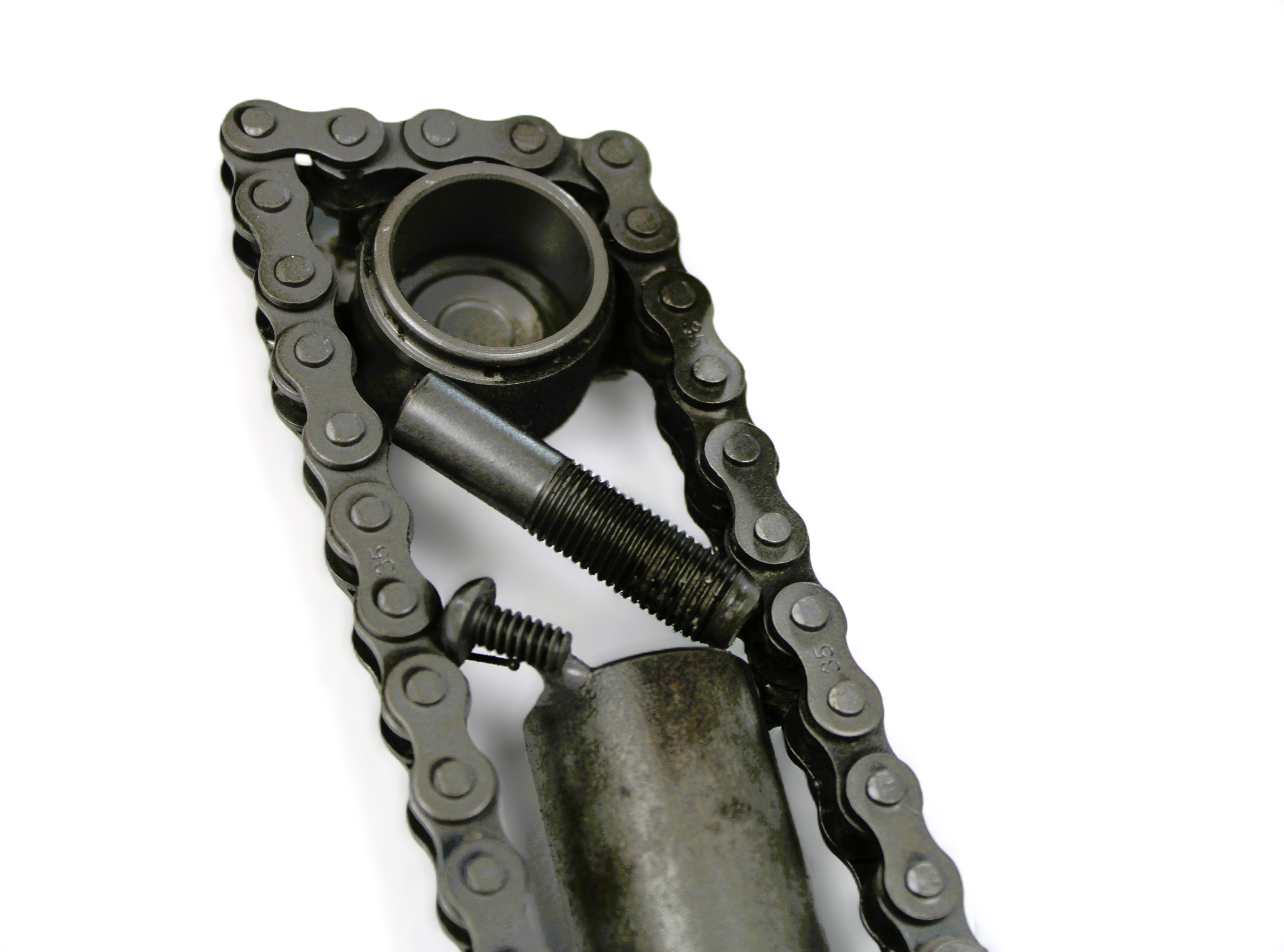 Close-up view of a letter V made out of real car parts, outlined with a timing chain.