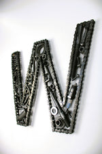 Load image into Gallery viewer, A letter W made out of real car parts, outlined with a timing chain.
