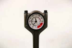 Close-up view of a polished car piston clock with a black clock ring and white and red RPM clock face.