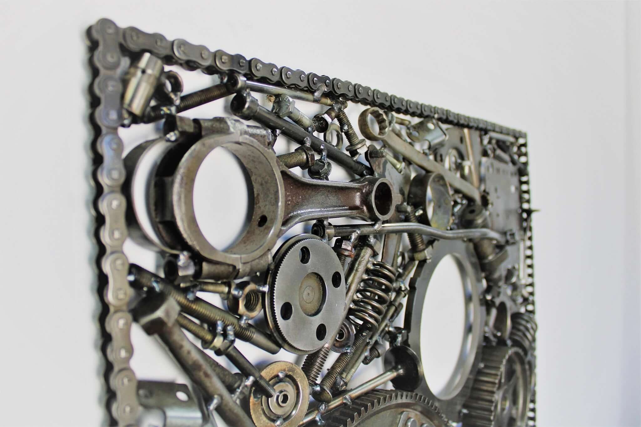 Handcrafted metal wall art piece outlined with timing chain and filled in entirely with polished genuine car engine components.