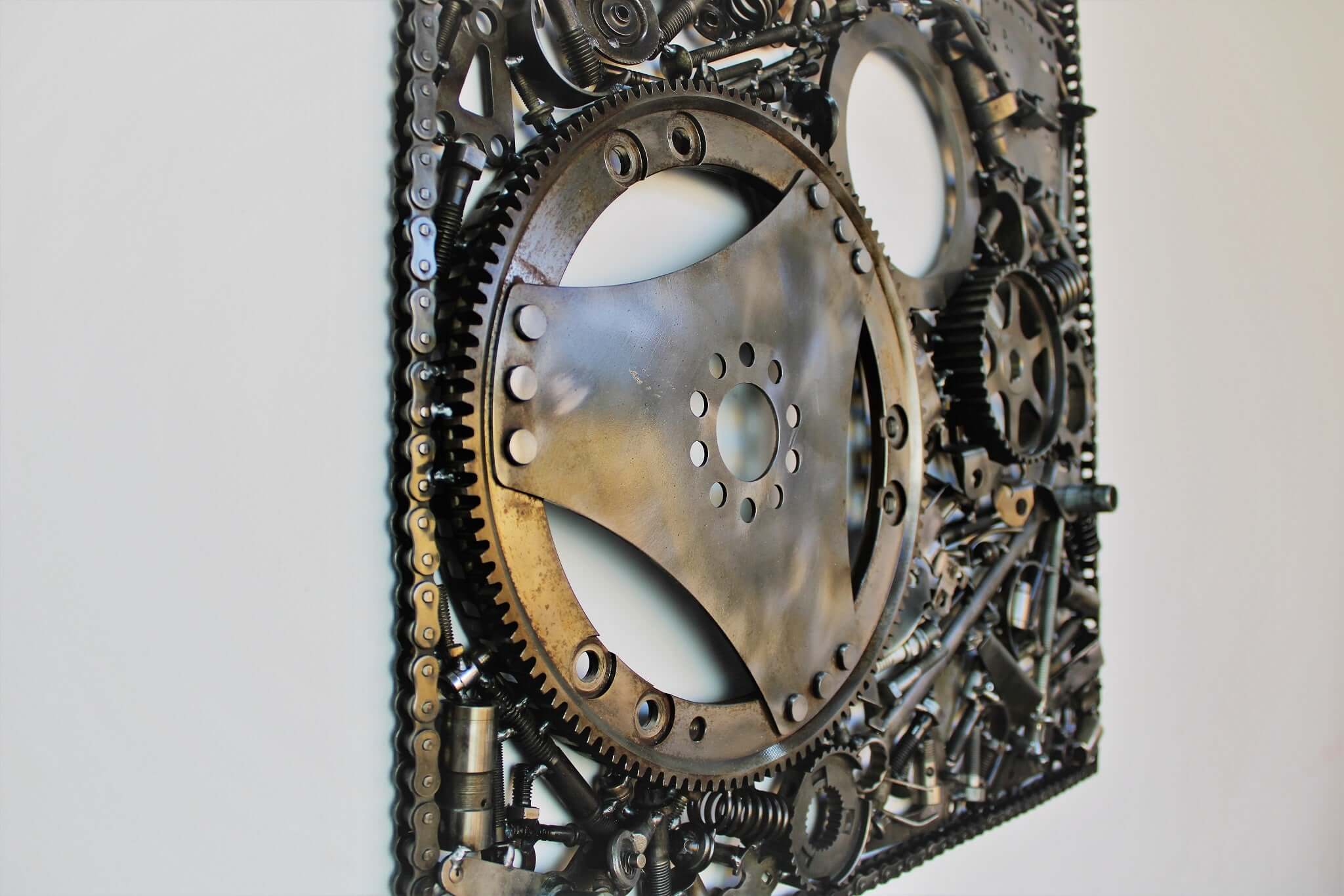 Handcrafted metal wall art piece outlined with timing chain and filled in entirely with polished genuine car engine components.