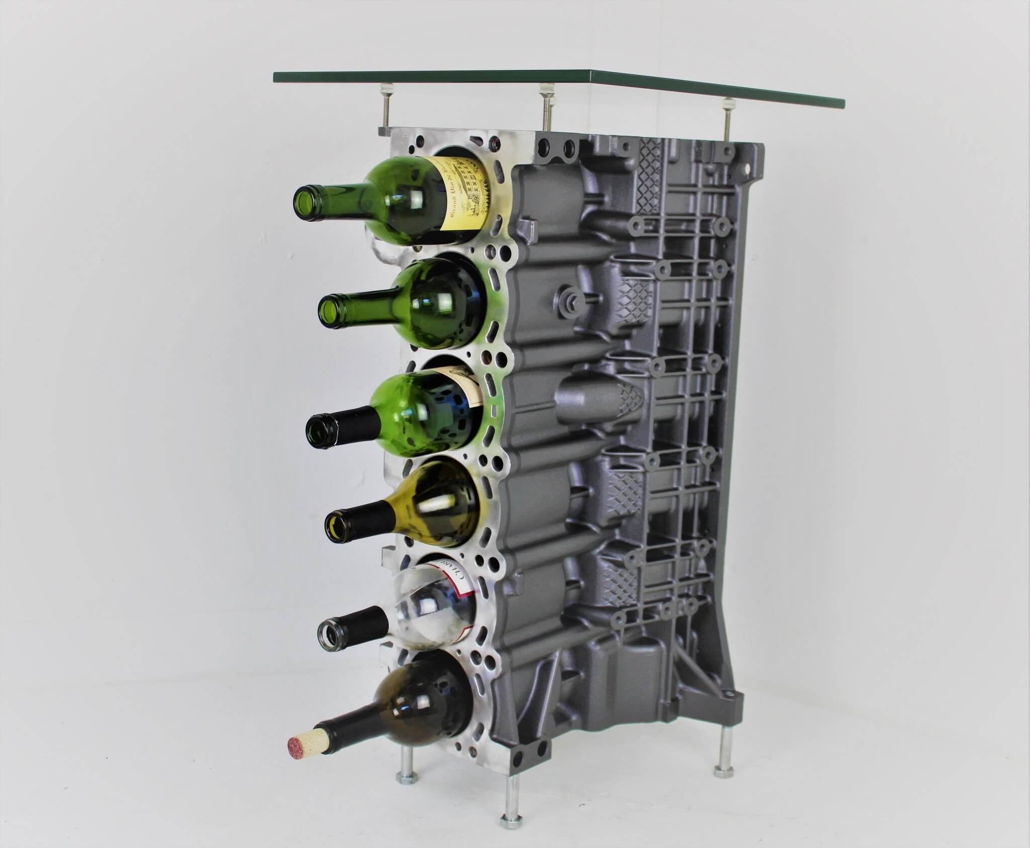 Wine rack table handcrafted from a genuine BMW car engine block finished in gray and silver with a square glass top.