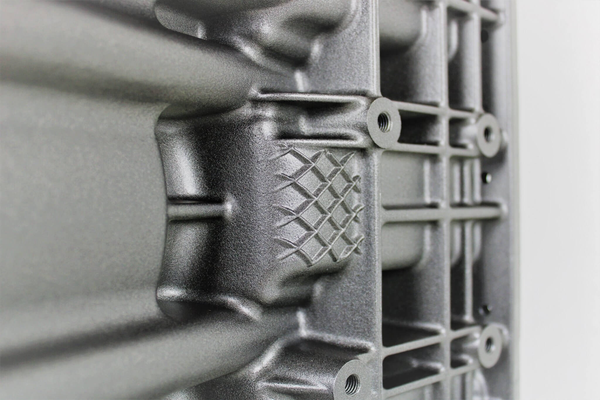 Wine rack table handcrafted from a genuine BMW car engine block finished in gray and silver with a square glass top.