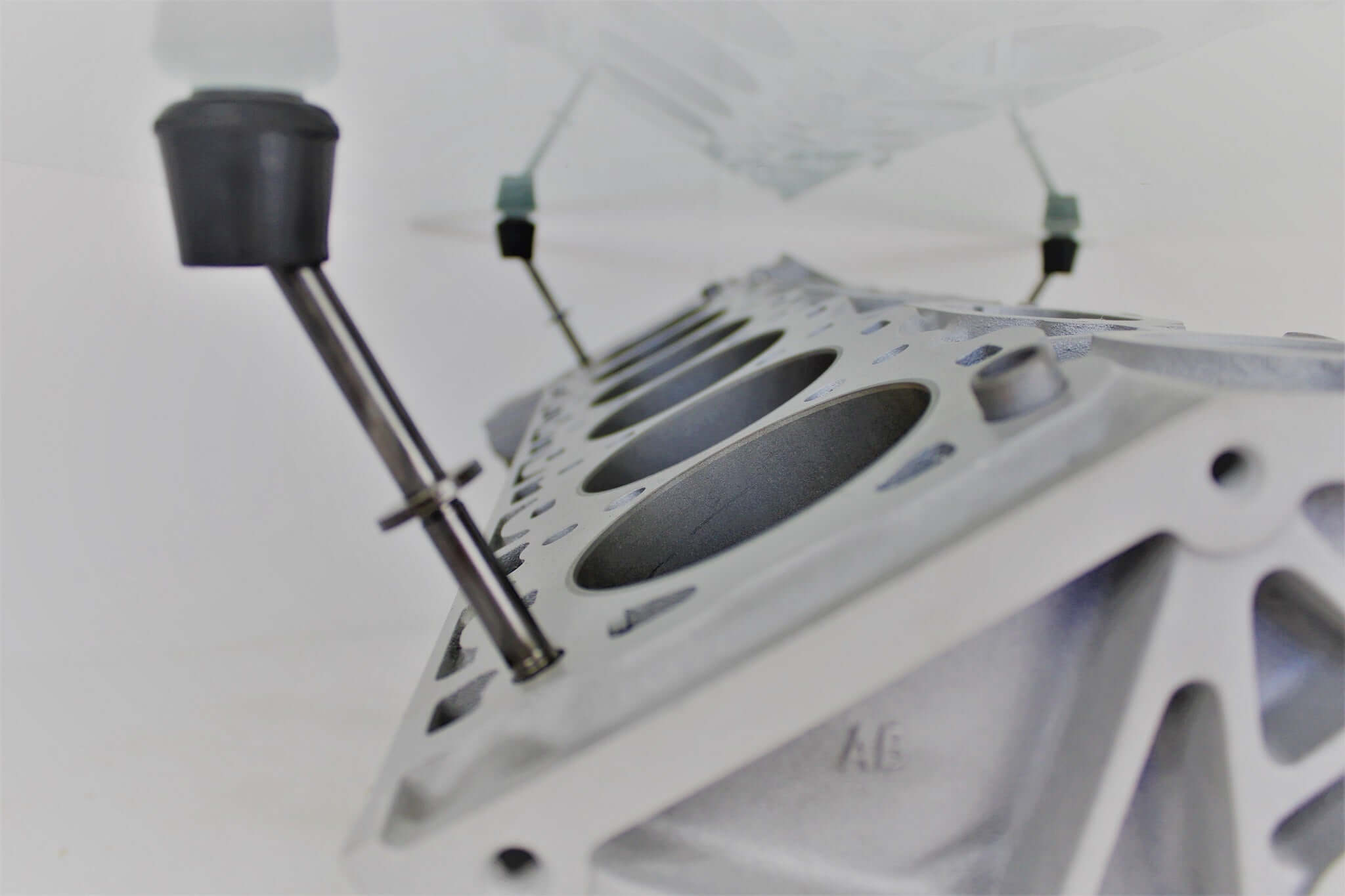 Coffee tables handcrafted from genuine car engines with various colored finishes, logos displayed, and glass top shapes.