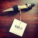 Load image into Gallery viewer, Bottle stopper made from a car&#39;s spark plug with a tag reading, &quot;B.A.D., Ben&#39;s Automotive Decor&quot;
