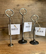 Load image into Gallery viewer, Three bottle openers made out of car engine valves with tags reading, &quot;B.A.D., Ben&#39;s Automotive Decor&quot;
