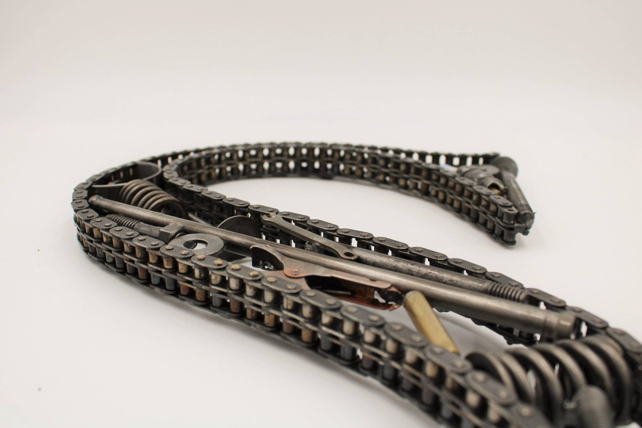 Hand-welded letter monogram decorations outlined with timing chain and filled in entirely with genuine polished car engine components with a glossy finish.