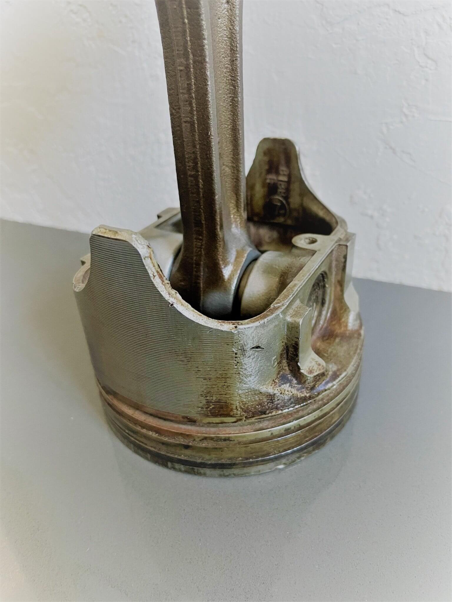 Tabletop clock handcrafted from a genuine car engine piston with a black and red clock face emulating a race car dashboard.