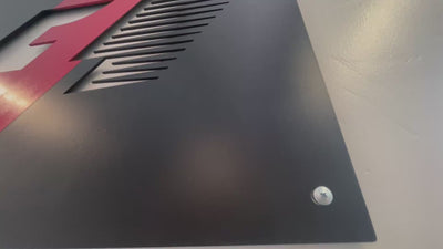 Video of a square cutout wall art sign displaying the F1 logo finished in black with a red stripe.