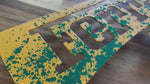 Load and play video in Gallery viewer, Video of a metal wall art piece of the Ferrari prancing horse logo, hand painted in yellow with green, white and red splatters.
