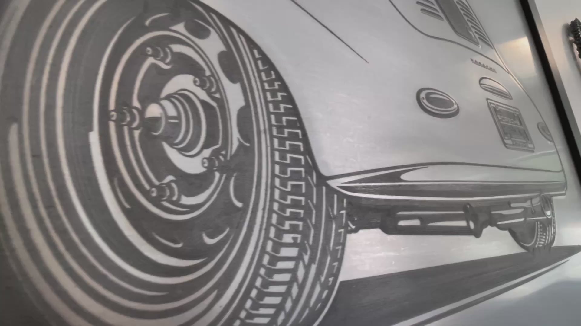 Video of a 38 inches x 26 inches bead-rolled art piece of a Porsche 356 car embossed on a sheet of steel in a black frame.