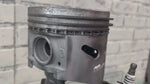 Load and play video in Gallery viewer, Video of a standing piston man car part sculpture holding a spark plug.
