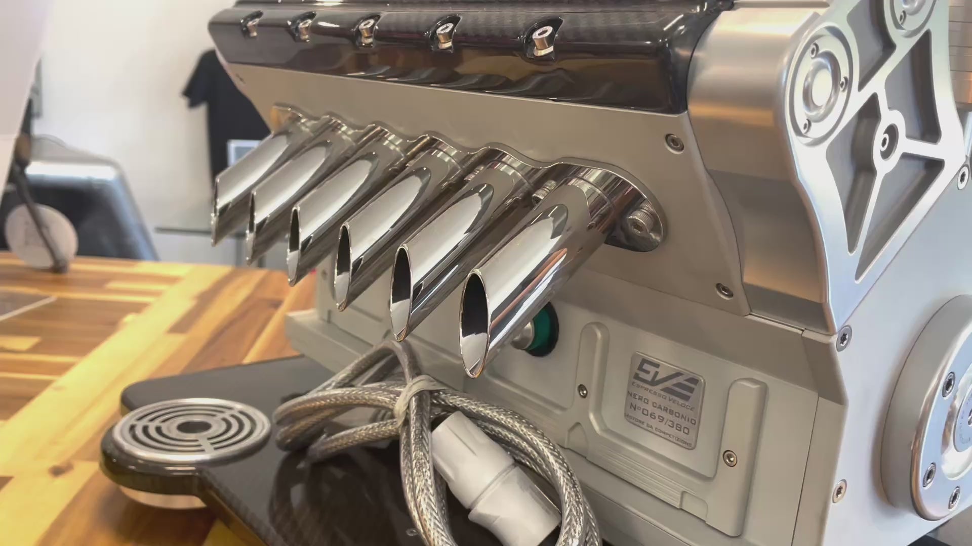 Video of a red, black and silver espresso maker made to look like a V12 car engine.