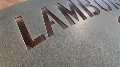 Carved metal Lamborghini crest wall art hand-painted in a metallic gold.