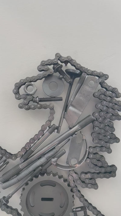Ferrari prancing horse logo art piece, made out of car parts and outlined with a timing chain.