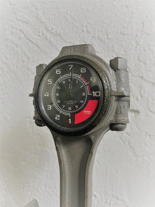 Clock made from a Chevrolet car's piston with a custom black and red RPM clock face.