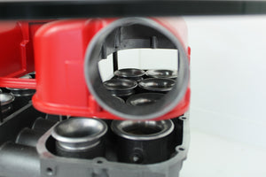Close-up view of a Ferrari intake manifold table, finished in red and gunmetal gray.