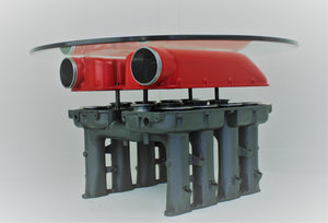 Ferrari intake manifold table finished in red and gunmetal gray with a round glass top.