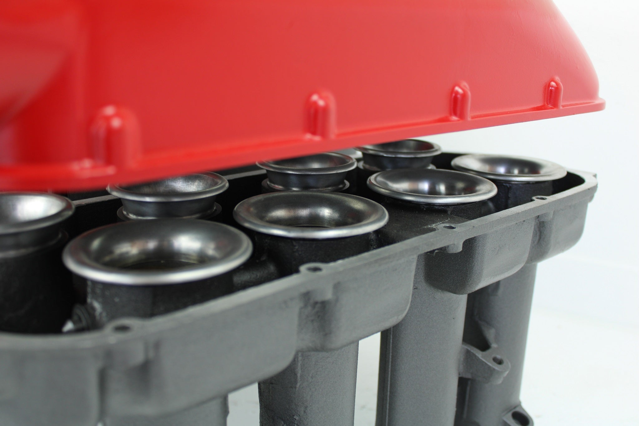 Close-up view of a Ferrari intake manifold table, finished in red and gunmetal gray.