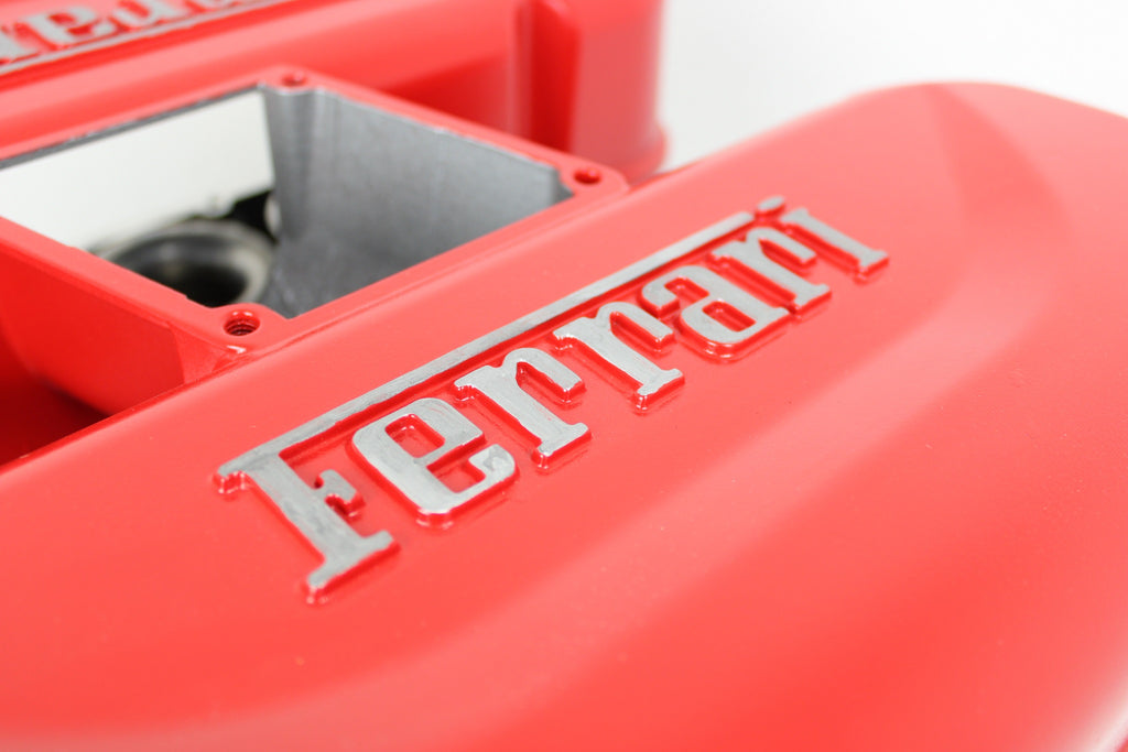 Close-up of a Ferrari intake manifold table, the Ferrari logo displayed in the center.
