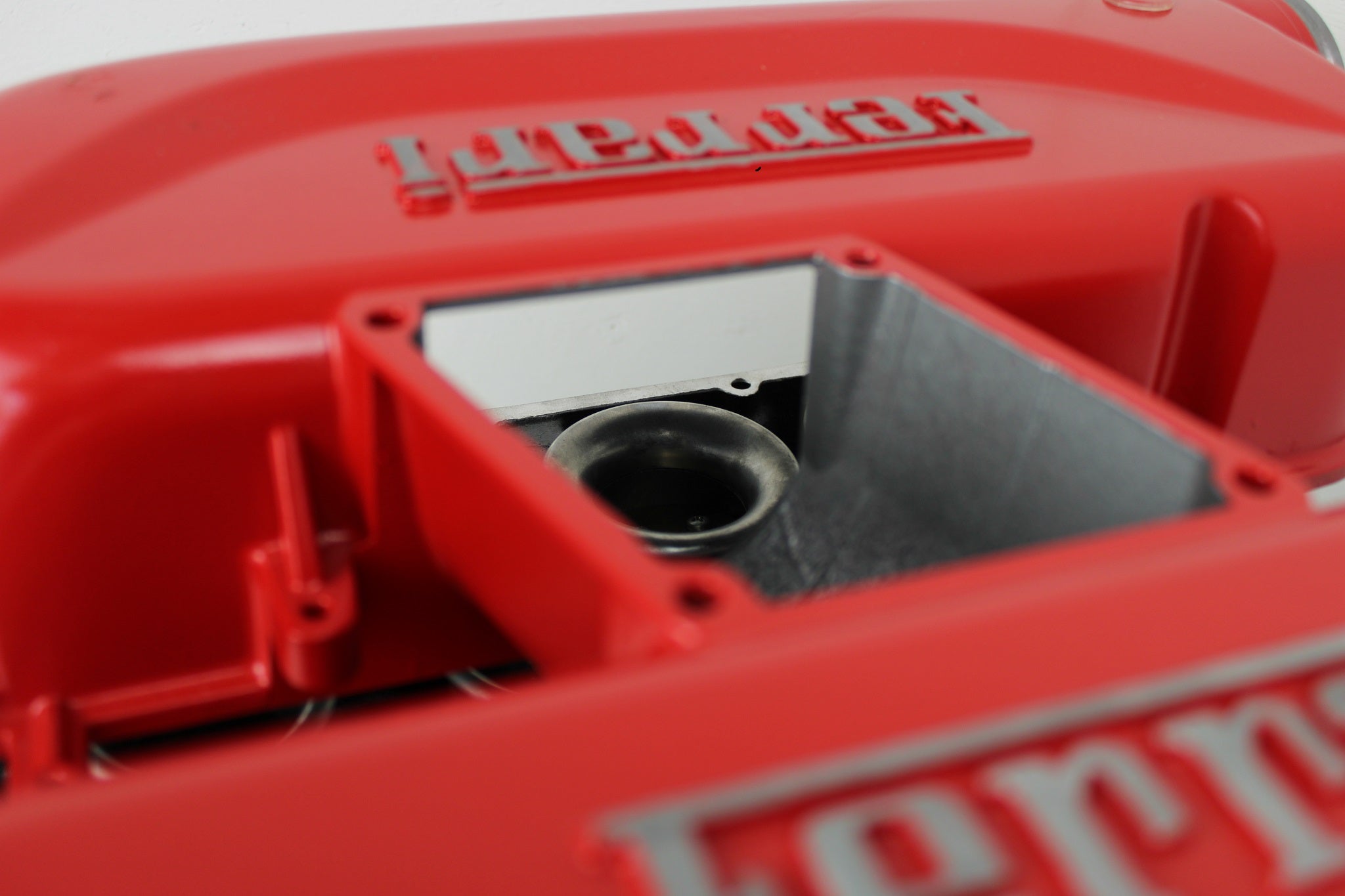 Close-up view of a Ferrari intake manifold table, the Ferrari logo displayed on both sides.