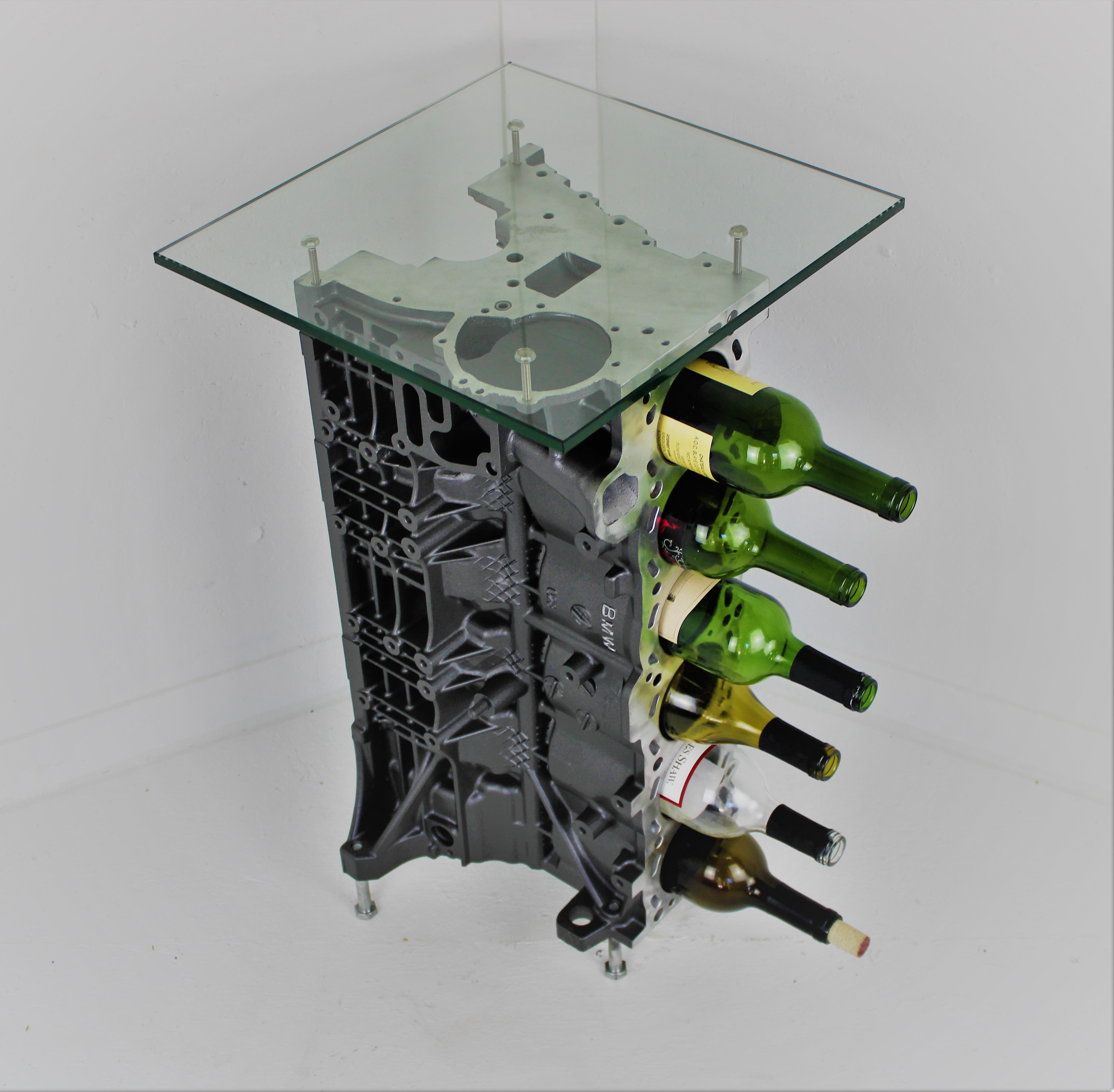 BMW end table and wine rack with six wine bottles stored inside, finished in gunmetal grey with a square glass top.