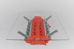 Load image into Gallery viewer, Birds-eye view of a Lamborghini Gallardo V10 engine block coffee table finished in orange with a square glass top.

