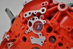 Load image into Gallery viewer, Close-up view of a Lamborghini Gallardo V10 engine block coffee table finished in orange with a square glass top.
