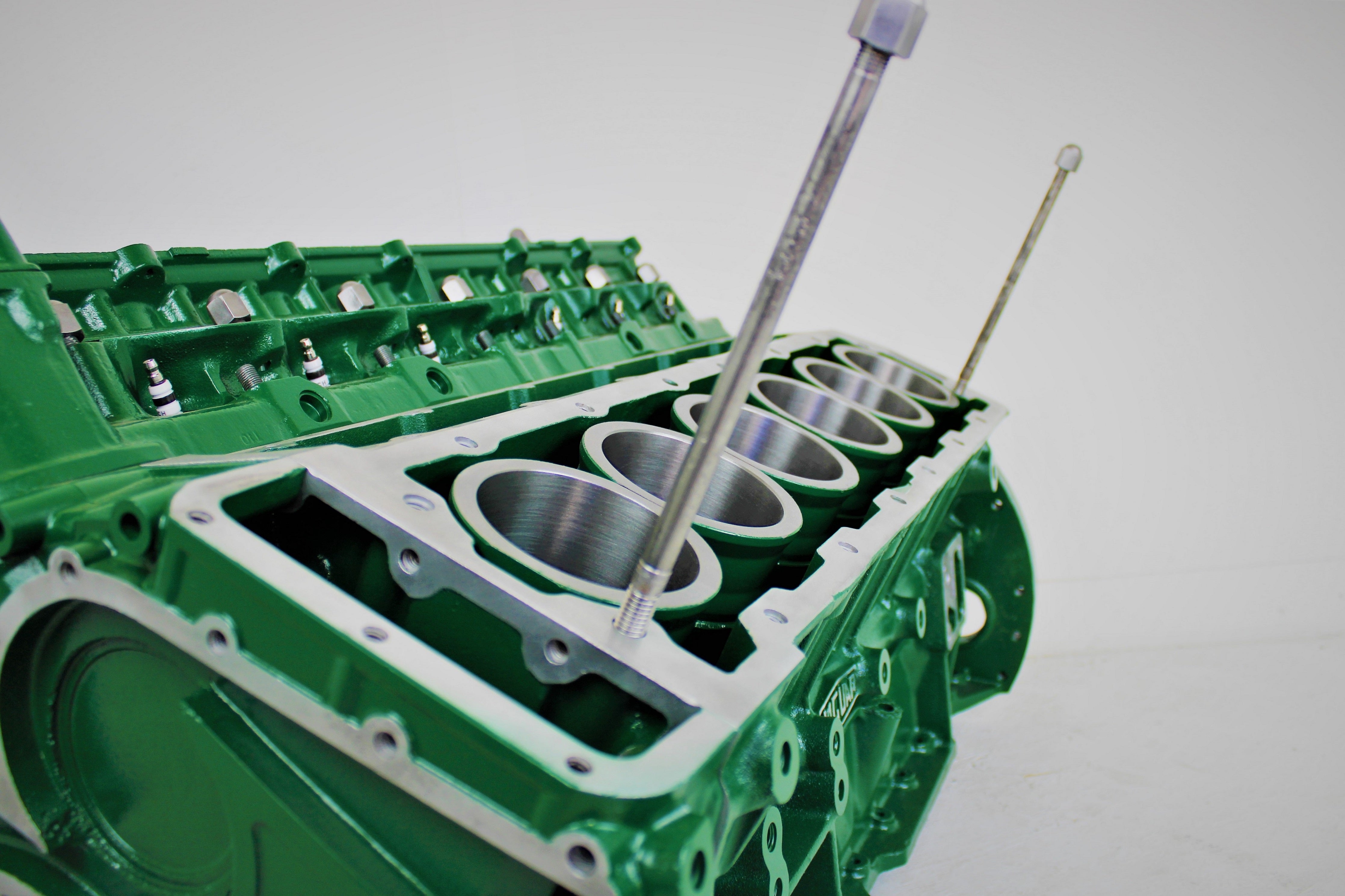 Close-up view of a Jaguar V12 engine block coffee table, finished in British Racing Green without its glass top.