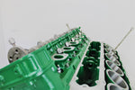 Load image into Gallery viewer, Close-up view of a Jaguar V12 engine block coffee table, finished in British Racing Green without its glass top.
