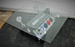 Load image into Gallery viewer, BMW M Series V10 engine block coffee table painted in the BMW M-Power color scheme with a square glass top, the M-Power logo displayed across the piece, and the BMW logo on each of the four car pistons.
