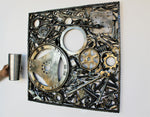Load image into Gallery viewer, Automotive wall art made out of real car parts, 24 by 24 inch square wall hanging, next to a metal thermos for scale
