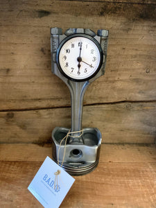 A silver desk clock made out of a genuine Audi car engine piston.